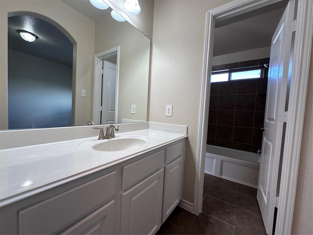 6549 Compass Ridge Drive Dallas, TX 75249 - Photo 14 of 19 a bathroom with a sink a toilet and shower