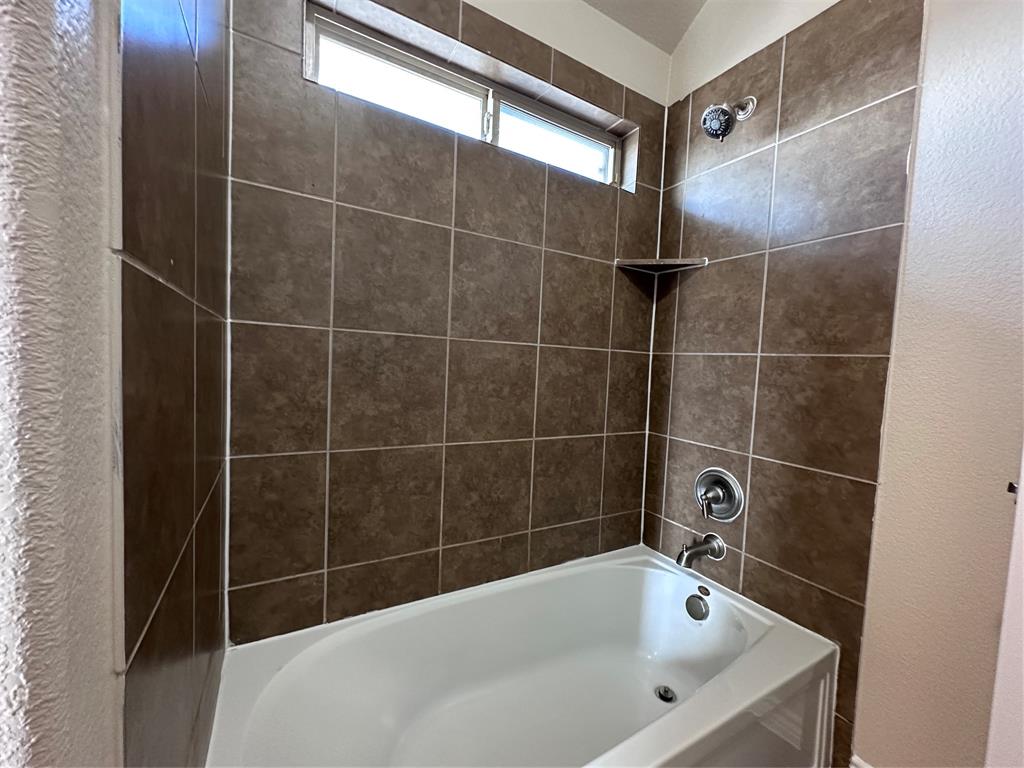 6549 Compass Ridge Drive Dallas, TX 75249 - Photo 16 of 19 a bathroom with a bathtub and a shower