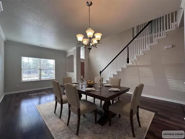a view of a dining room with furniture wooden floor and chandelier
