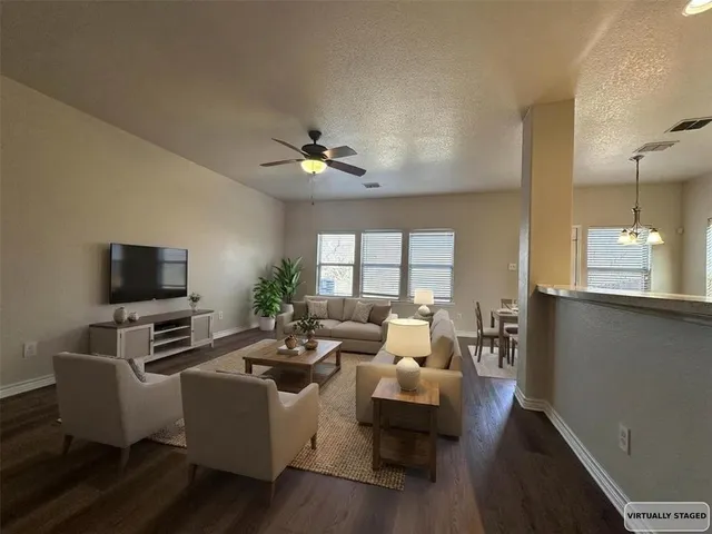a living room with furniture a flat screen tv and a window