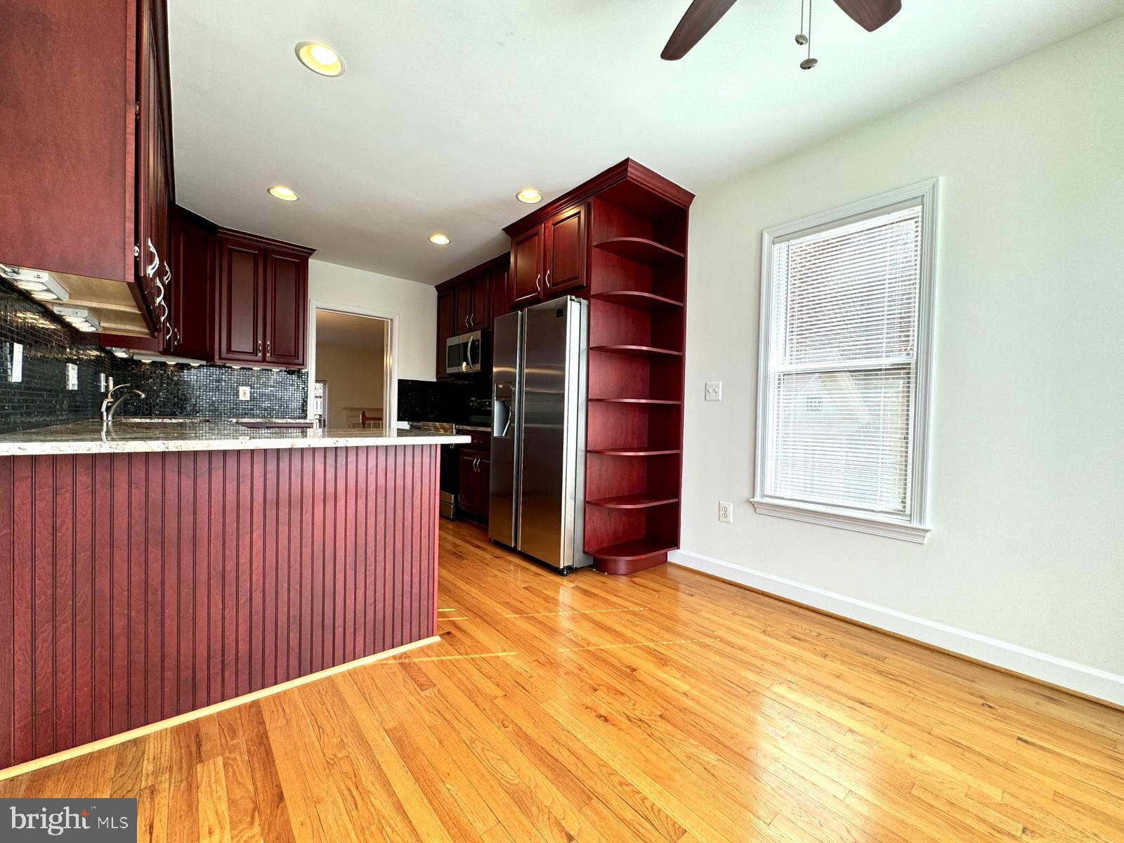 1447 Hampton Hill Circle McLean, VA 22101 - Photo 17 of 46 a kitchen with stainless steel appliances kitchen island granite countertop a refrigerator stove oven and white cabinets with wooden floor