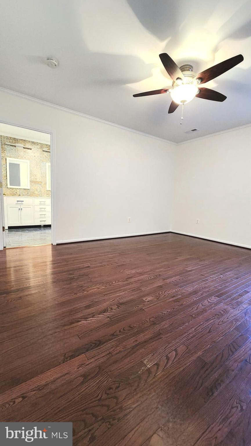1447 Hampton Hill Circle McLean, VA 22101 - Photo 21 of 46 an empty room with wooden floor chandelier fan and windows