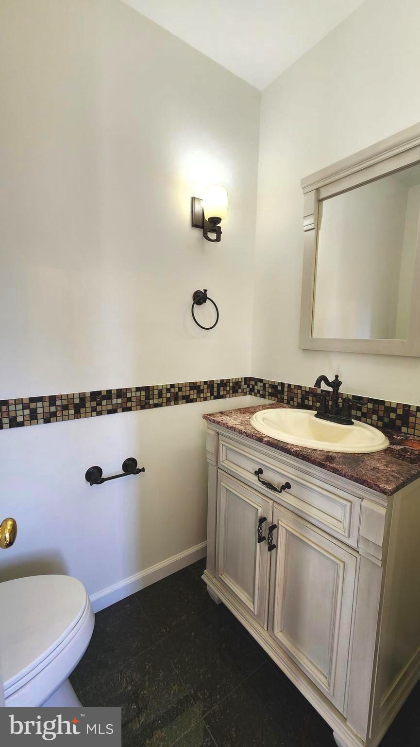 1447 Hampton Hill Circle McLean, VA 22101 - Photo 8 of 46 a bathroom with a granite countertop sink a toilet and a mirror