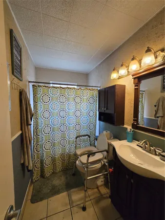 a bathroom with a sink mirror and a shower