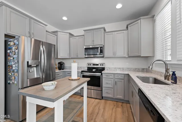 a kitchen with granite countertop cabinets stainless steel appliances and a sink
