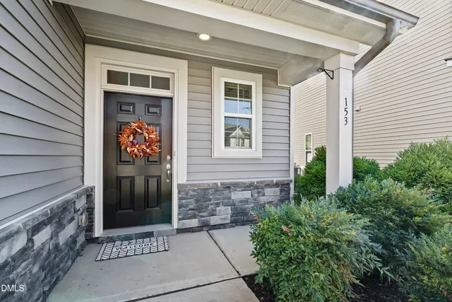 a front view of a house with plants
