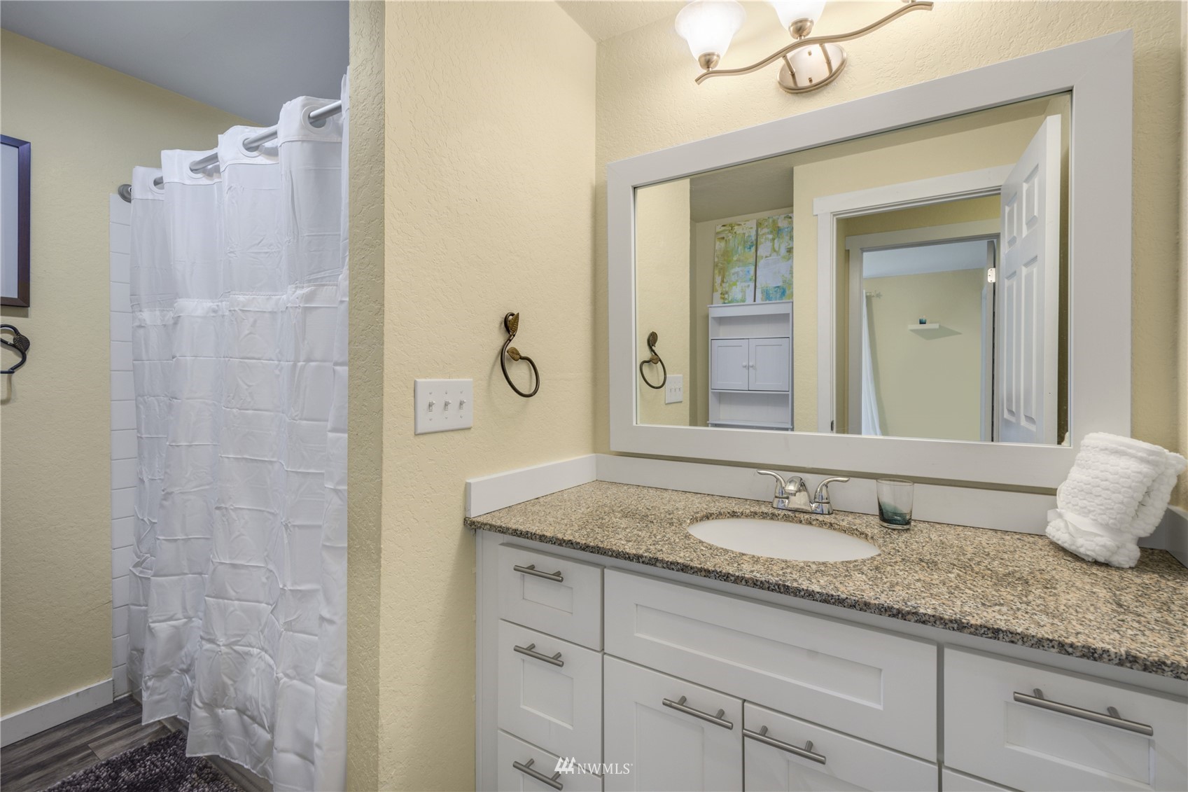 4100 Lake Washington Boulevard North, Unit D203 Renton, WA 98056 - Photo 24 of 30 a bathroom with a granite countertop sink a mirror and shower
