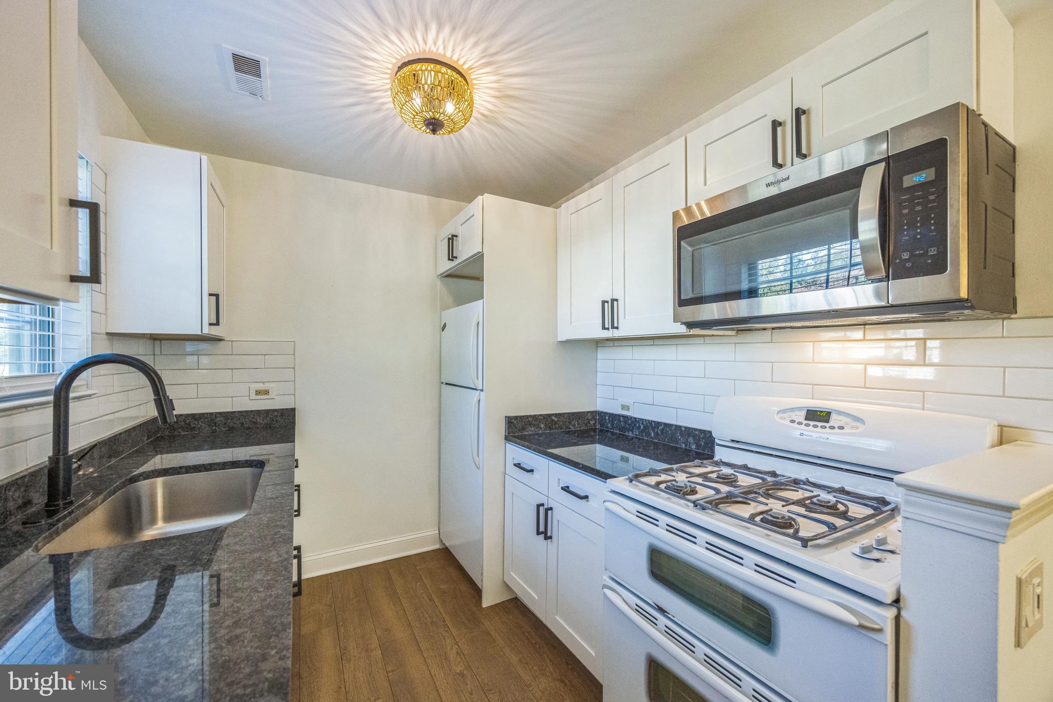 180 Tavistock Road Cherry Hill, NJ 08034 - Photo 4 of 15 a kitchen with stainless steel appliances granite countertop a stove a sink and a microwave
