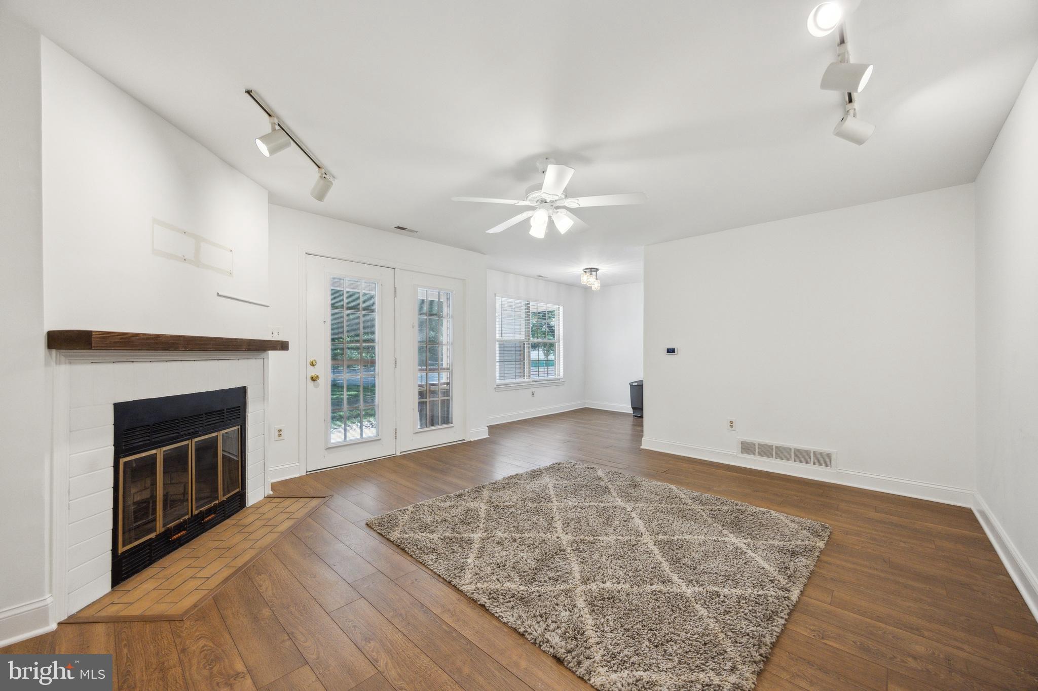 180 Tavistock Road Cherry Hill, NJ 08034 - Photo 5 of 15 wooden floor fireplace and windows in an empty room