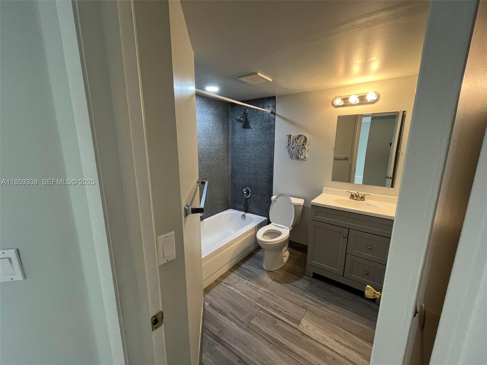 8821 Wiles Road, Unit 203 Coral Springs, FL 33067 - Photo 12 of 30 a bathroom with a double vanity sink toilet and shower