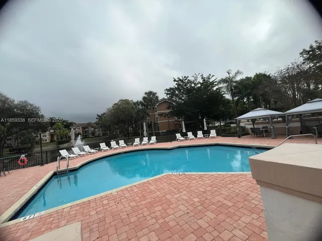 a view of swimming pool with outdoor seating and lake view