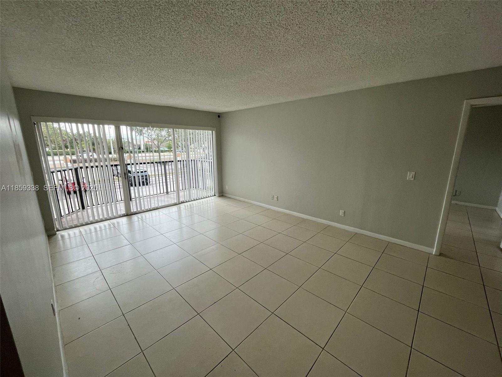 8821 Wiles Road, Unit 203 Coral Springs, FL 33067 - Photo 4 of 30 an empty room with windows