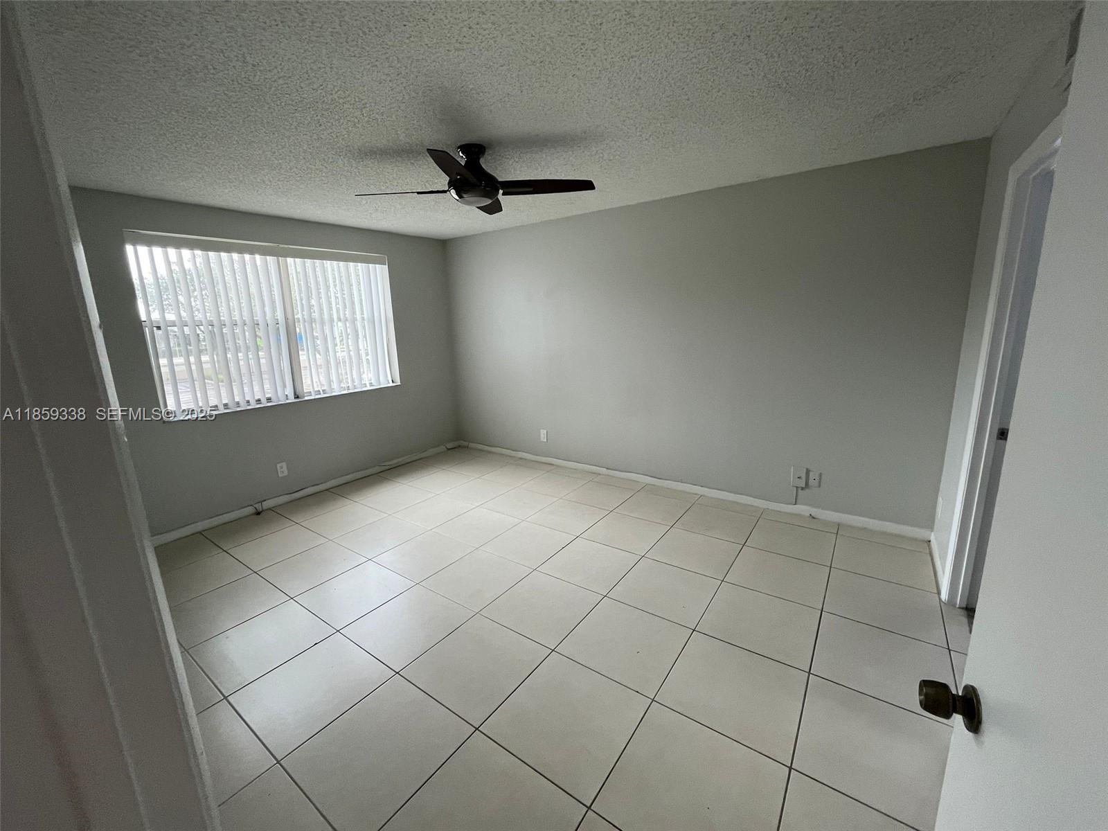 8821 Wiles Road, Unit 203 Coral Springs, FL 33067 - Photo 7 of 30 a view of an empty room with a window
