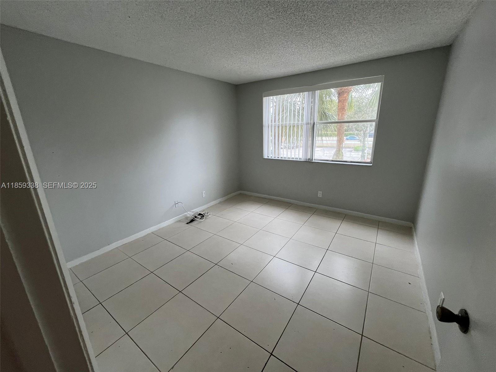 8821 Wiles Road, Unit 203 Coral Springs, FL 33067 - Photo 8 of 30 an empty room with windows