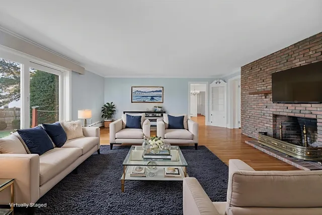 a living room with furniture a flat screen tv and a fireplace