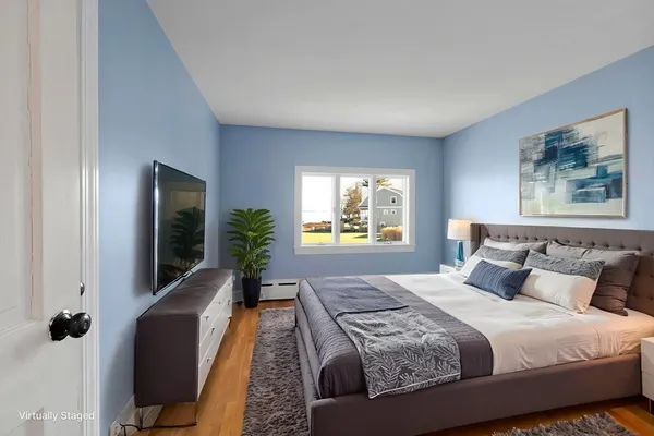 a bedroom with a large bed and a flat tv screen on dresser
