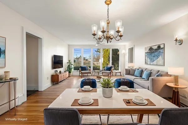 a view of a dining room with furniture a chandelier and wooden floor