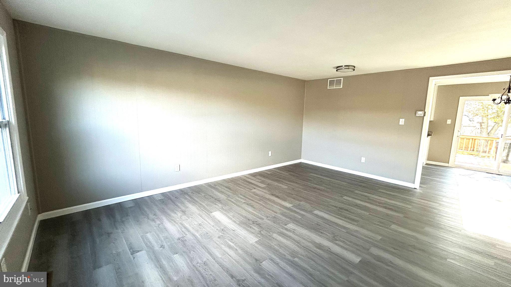 13 Consett Place, Unit 4H Frederick, MD 21703 - Photo 3 of 21 an empty room with wooden floor and windows