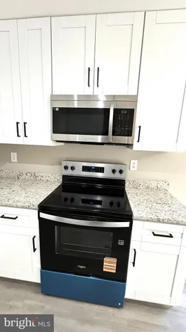 a kitchen with stainless steel appliances granite countertop a stove and a microwave