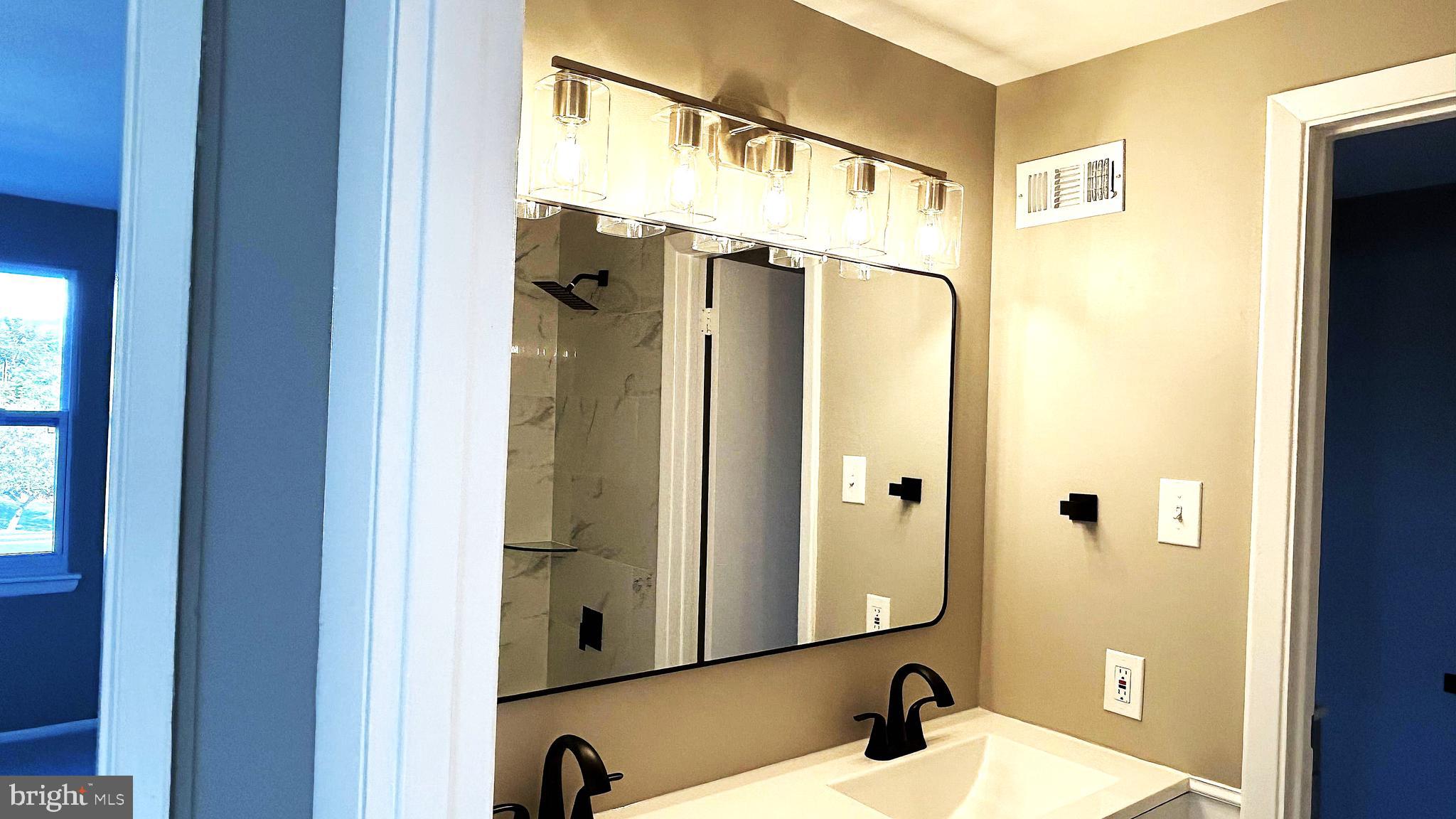 13 Consett Place, Unit 4H Frederick, MD 21703 - Photo 9 of 21 a bathroom with a shower sink and mirror