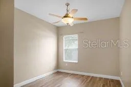 an empty room with a window and a fan