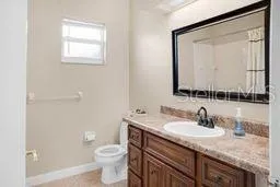 a bathroom with a granite countertop sink toilet and mirror