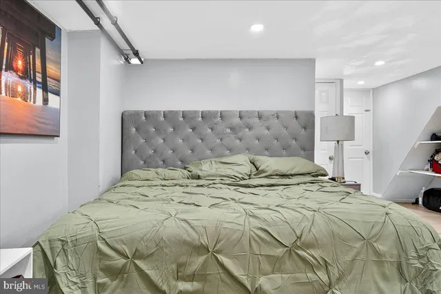 a room with a bed a chair and flat screen tv