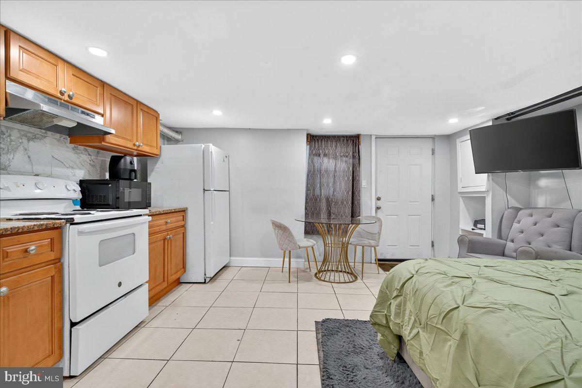 1440 Robbins Street Philadelphia, PA 19149 - Photo 26 of 31 a room with a bed a chair and flat screen tv