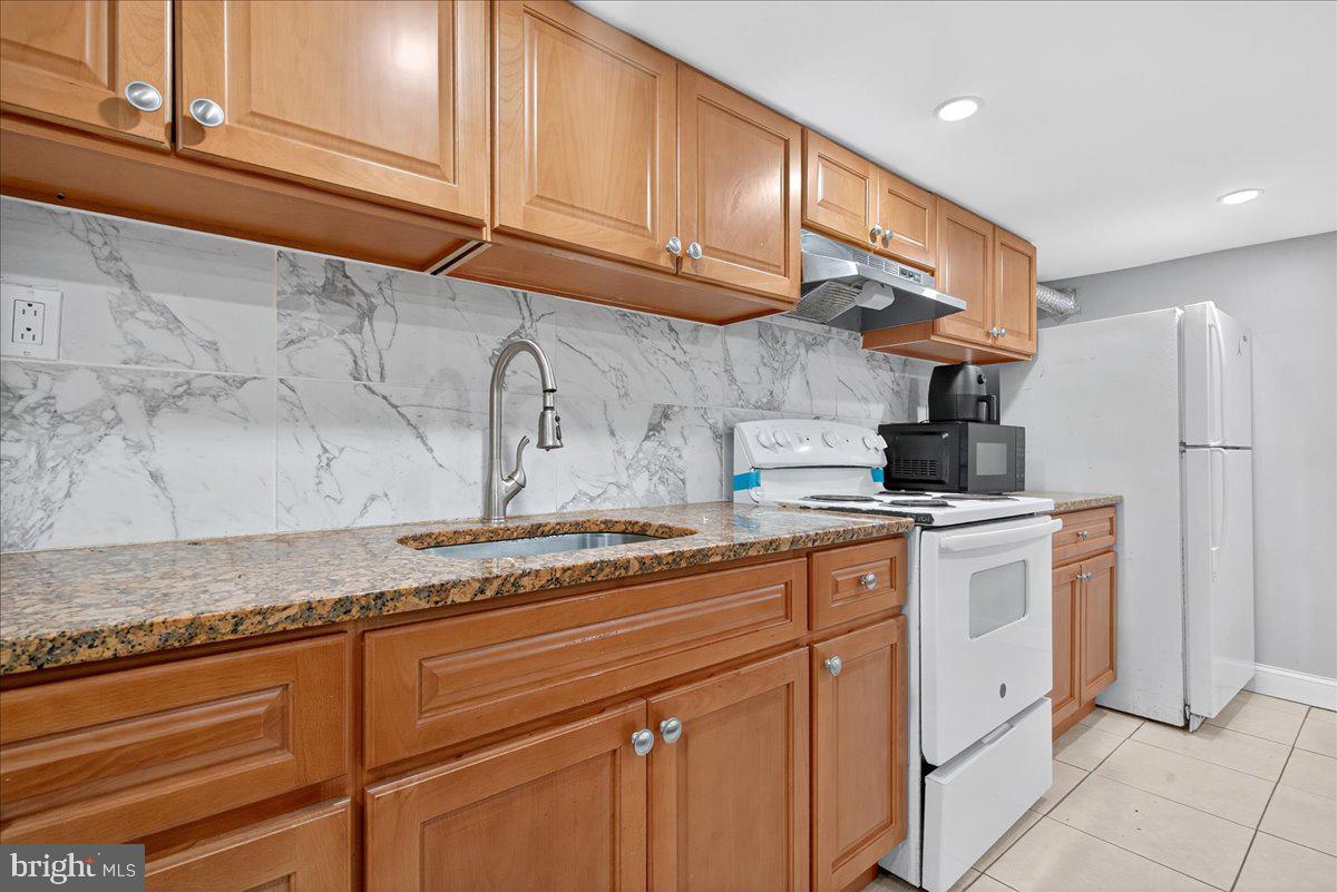 1440 Robbins Street Philadelphia, PA 19149 - Photo 27 of 31 a kitchen with stainless steel appliances granite countertop a sink a refrigerator and a stove