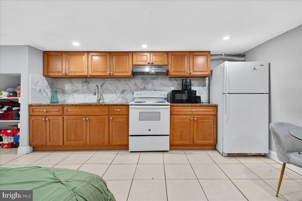 1440 Robbins Street Philadelphia, PA 19149 - Photo 28 of 31 a kitchen with a white cabinets and white appliances
