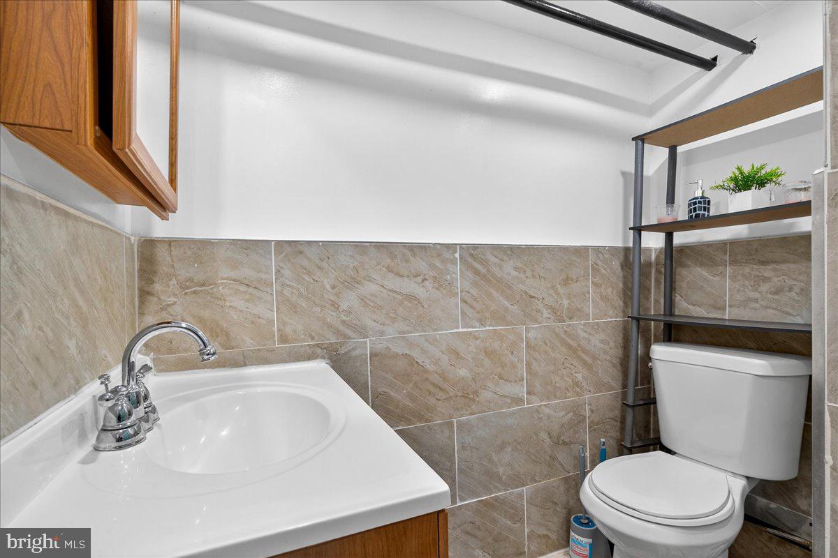 1440 Robbins Street Philadelphia, PA 19149 - Photo 30 of 31 a bathroom with a sink a toilet and a mirror