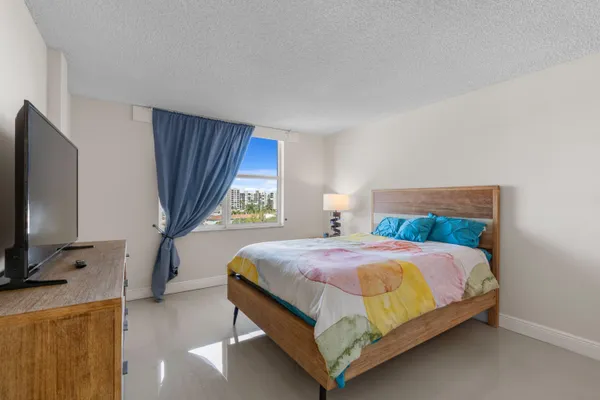 a bedroom with a bed tv and window