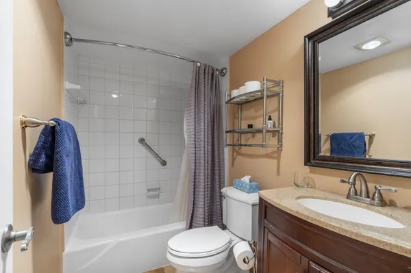 a bathroom with a granite countertop sink toilet and shower