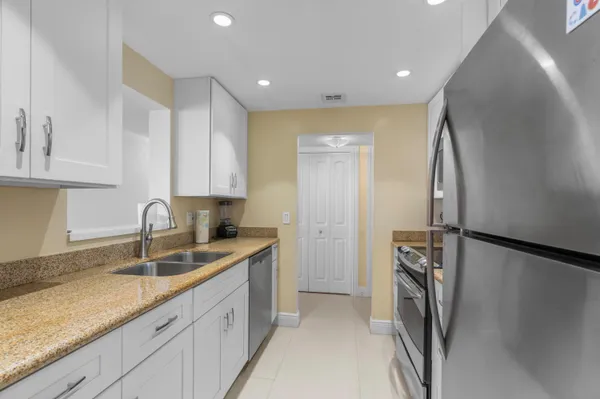 a kitchen with stainless steel appliances granite countertop a refrigerator and a sink