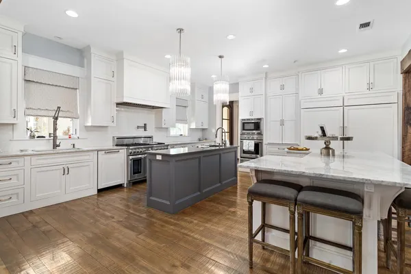 a kitchen with kitchen island granite countertop a sink a center island stainless steel appliances and cabinets