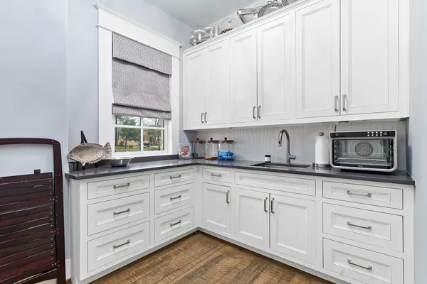 a kitchen with granite countertop white cabinets and white appliances