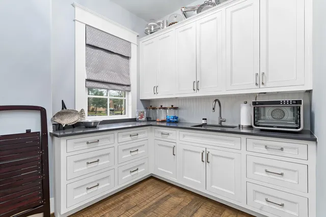 a kitchen with granite countertop white cabinets and white appliances