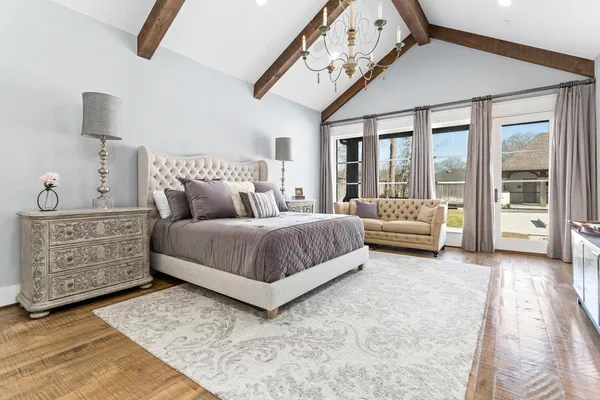 a bedroom with a large bed and a chandelier