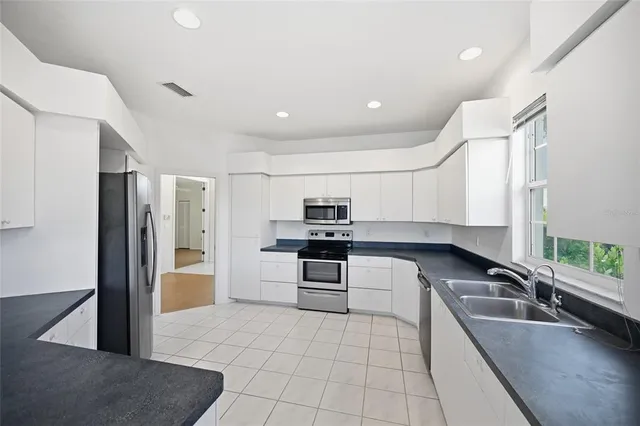 a kitchen with stainless steel appliances a refrigerator sink and window