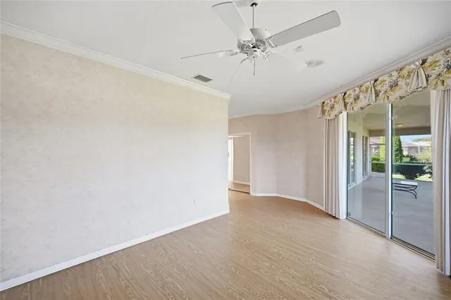 an empty room with fan and windows