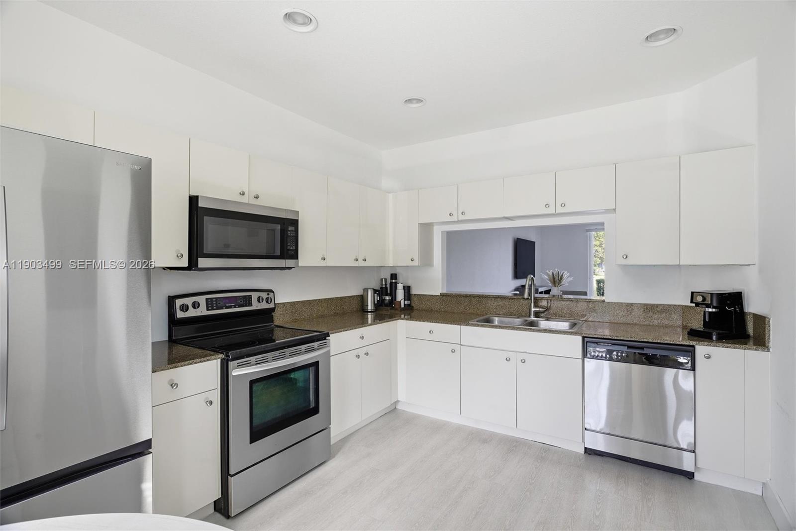 8231 Southwest 29th Street Miramar, FL 33025 - Photo 26 of 53 a kitchen with white cabinets stainless steel appliances and sink