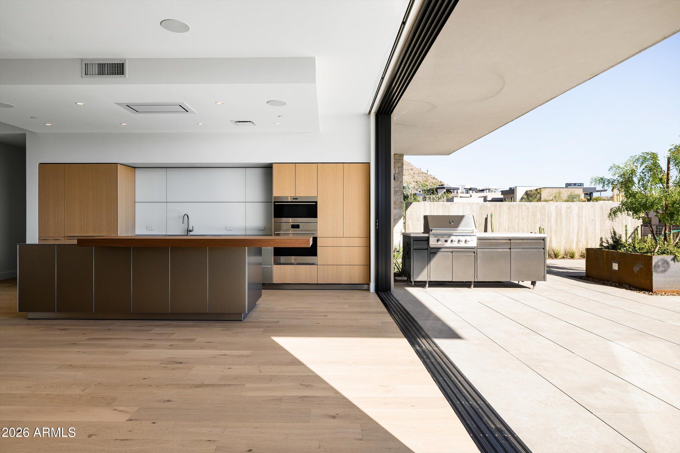 a large room with kitchen island a large counter space and stainless steel appliances