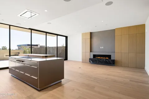 a view of a kitchen with kitchen island a counter top space a sink stainless steel appliances and cabinets