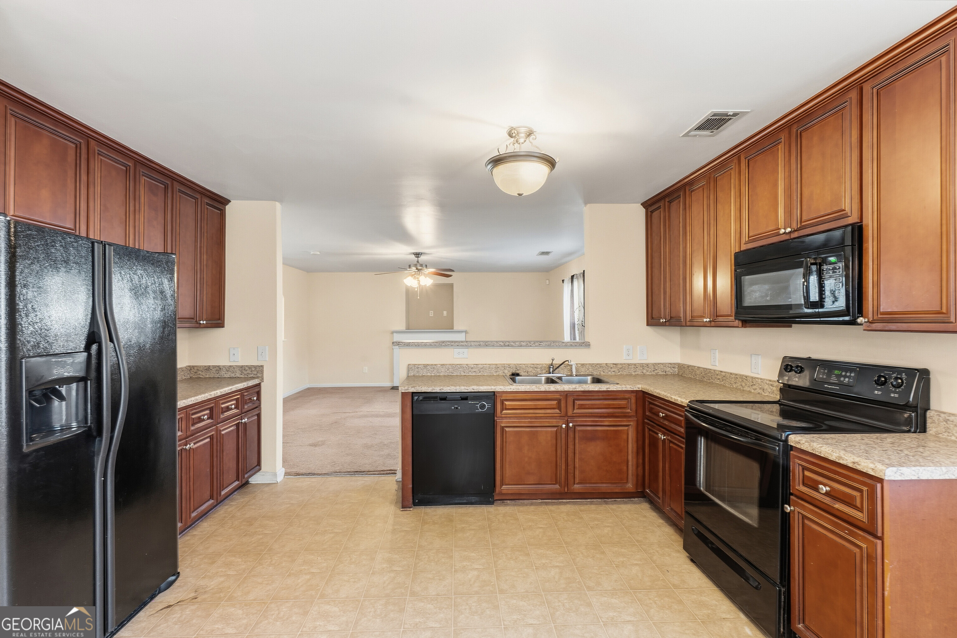 102 Steeple Court Perry, GA 31069 - Photo 11 of 37 a kitchen with stainless steel appliances granite countertop a sink a stove top oven a refrigerator with grey cabinets and stainless steel appliances
