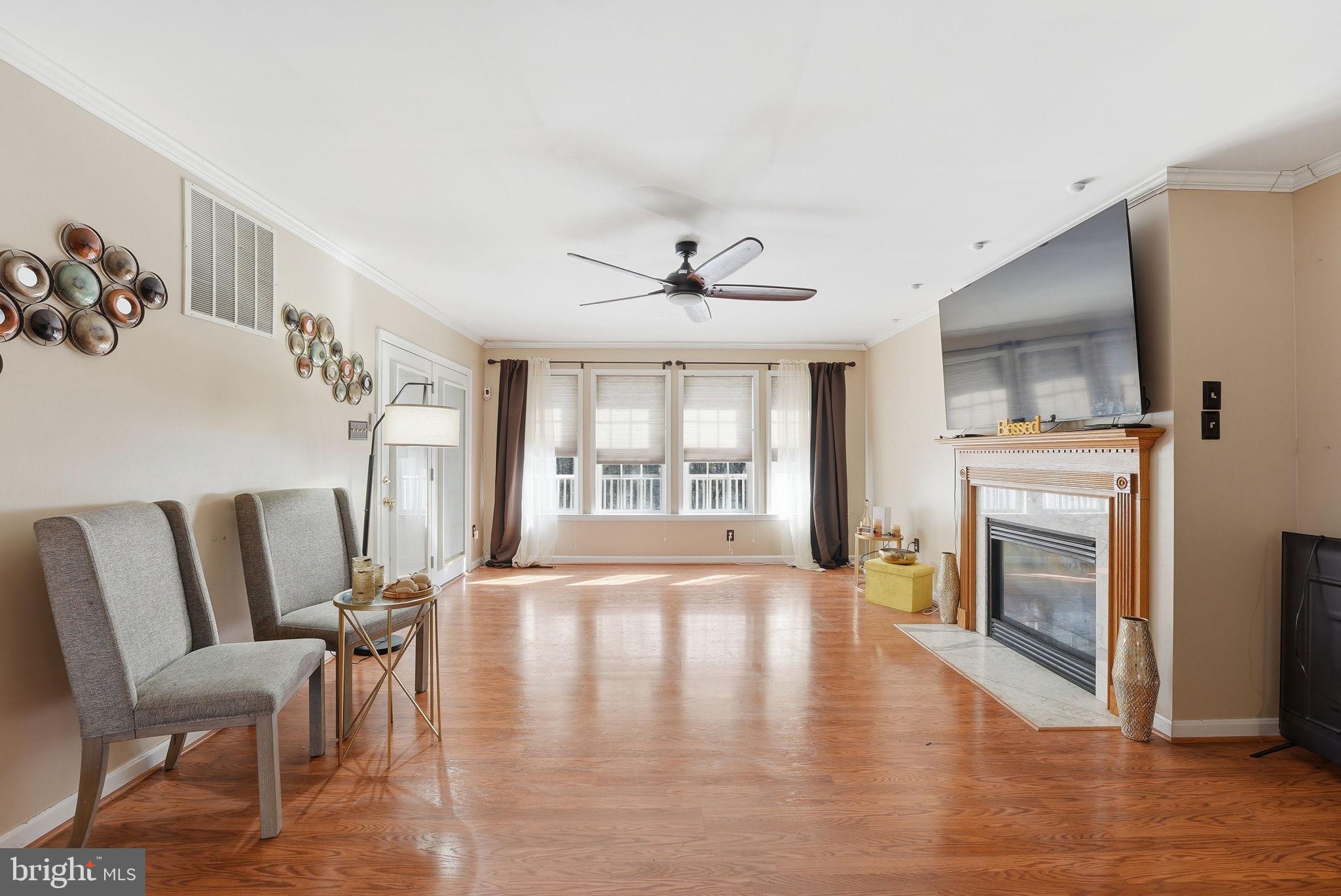 6870 Hawkins Gate Road La Plata, MD 20646 - Photo 7 of 24 a view of a livingroom with furniture a fireplace wooden floor and windows