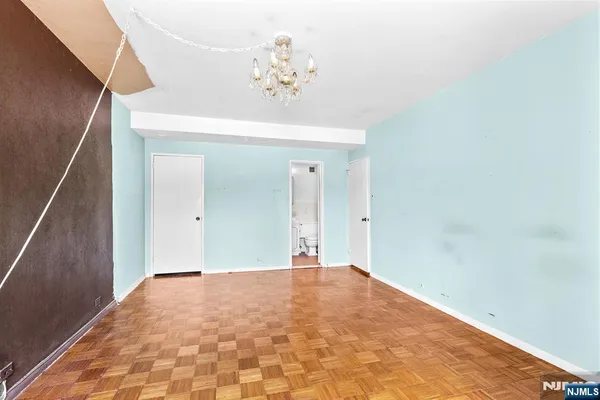a view of an empty room with wooden floor and entryway