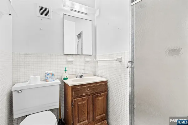 a bathroom with a toilet sink vanity and mirror