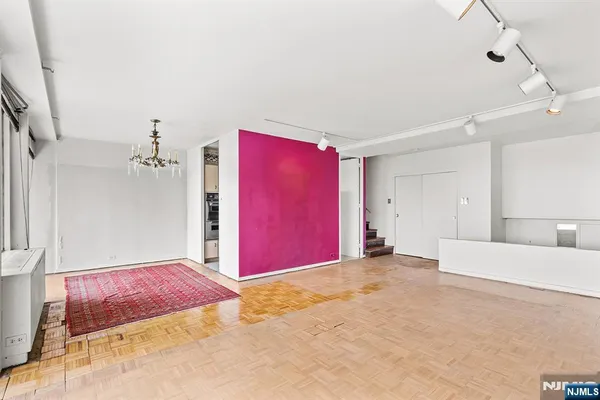 a view of an empty room with a chandelier fan