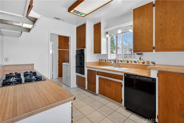 a kitchen with a stove cabinets and a window