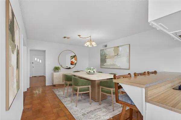 a room with a table chairs and a kitchen view
